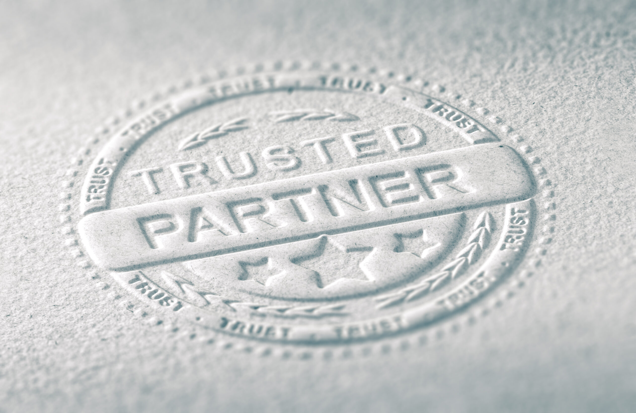 3D illustration of an embossed stamp with the text trusted partner, Paper background and blur effect. Concept of confidence in business relationship.